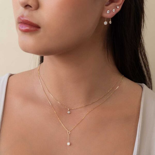 Model Wears Diamond Jen Round Medium Bezel Drop Enhancer Lou Round Small Bezel Yellow Gold Layered Pendant Cropped