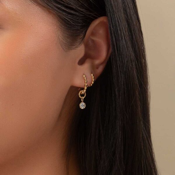 Model Wears Yellow Gold Lou Round Medium Bezel Diamond Charm With Hope Small Medium Ball Plain Hoop Earrings Cropped